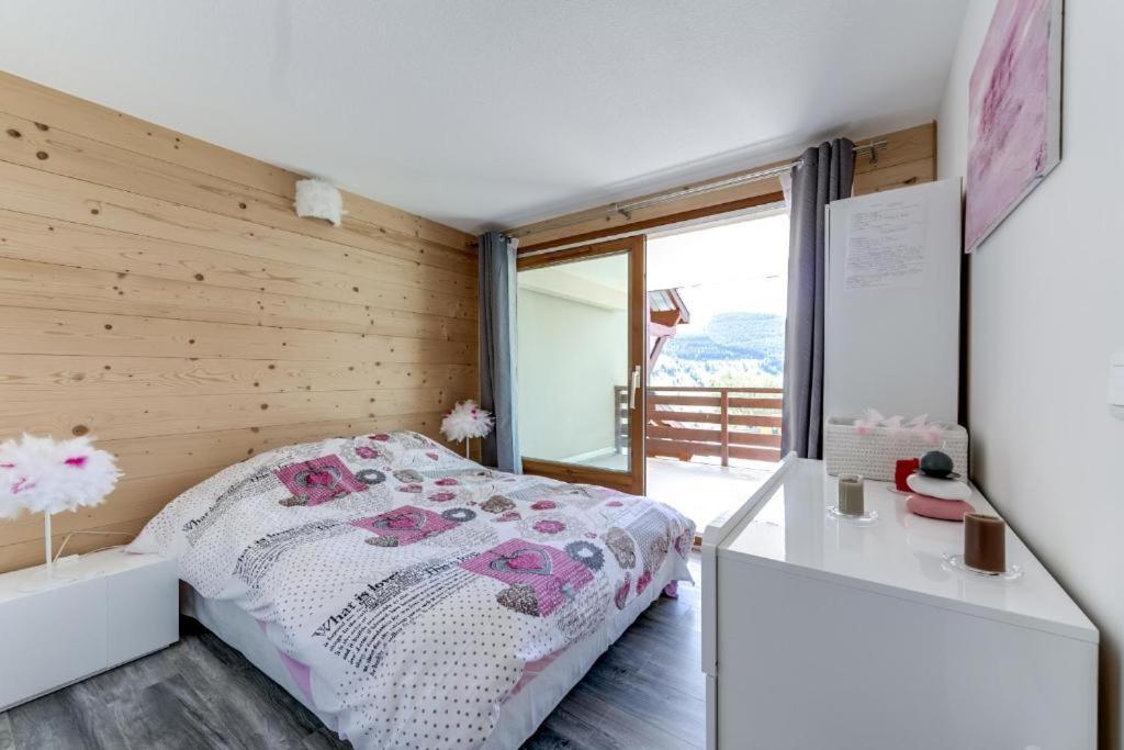 ein Schlafzimmer mit einem Bett und einer Holzwand in der Unterkunft Appartement moderne avec vue incroyable in Les Deux Alpes