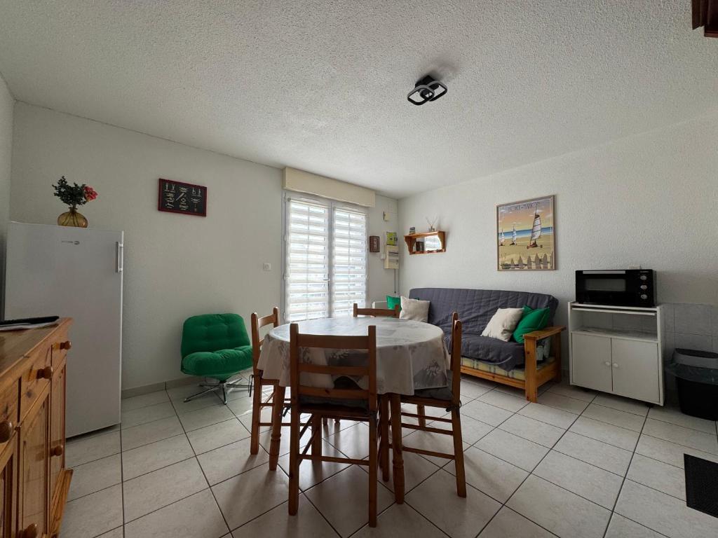 une cuisine et un salon avec une table et des chaises dans l'établissement L'Eclipse, à Fort-Mahon-Plage