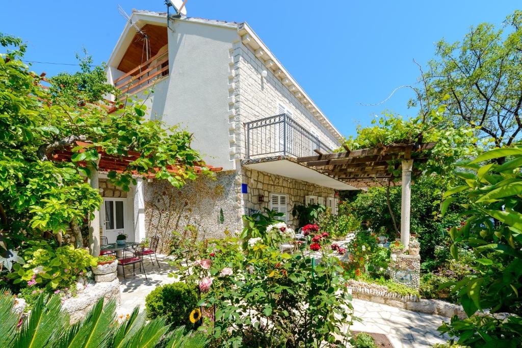 a house with flowers in front of it at Apartments Milić in Mlini