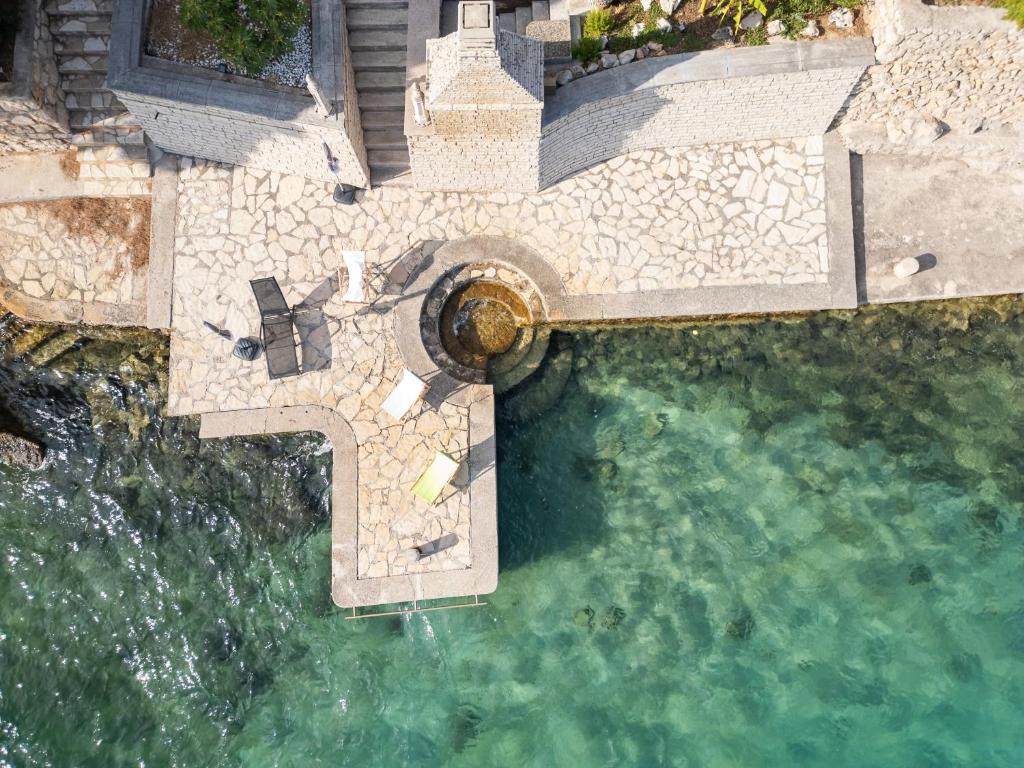 Pogled iz zraka na kamenu terasu, dimnjak i more ispred kuće SeVeN