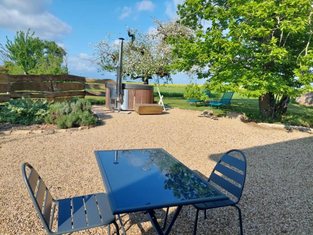 a blue table and chairs in a yard at Le Petit Sondebois in Saint-Gervais-en-Vallière
