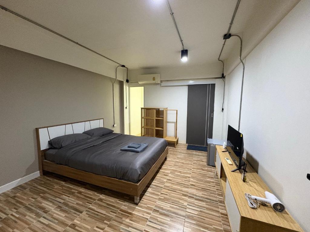 una camera da letto con un letto e una TV a schermo piatto di The beeroom by BoonmeeApt a Sathani Sam Sen