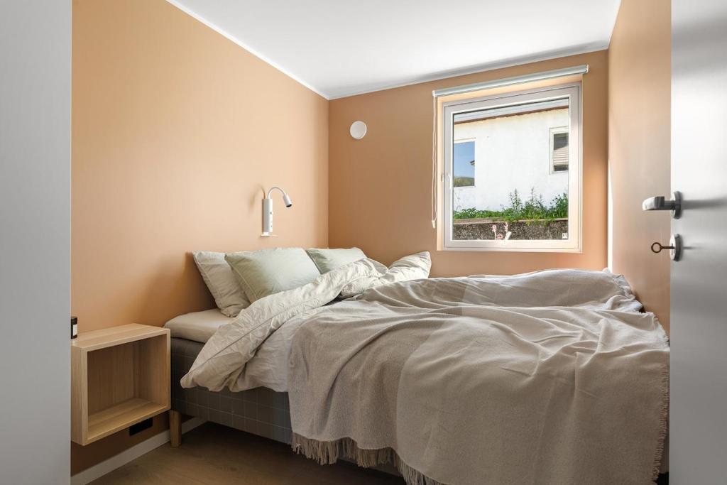 a bedroom with a bed and a window at Northstay - Tromsø Urban Retreat - Free Parking, Brand New & Modern in Tromsø