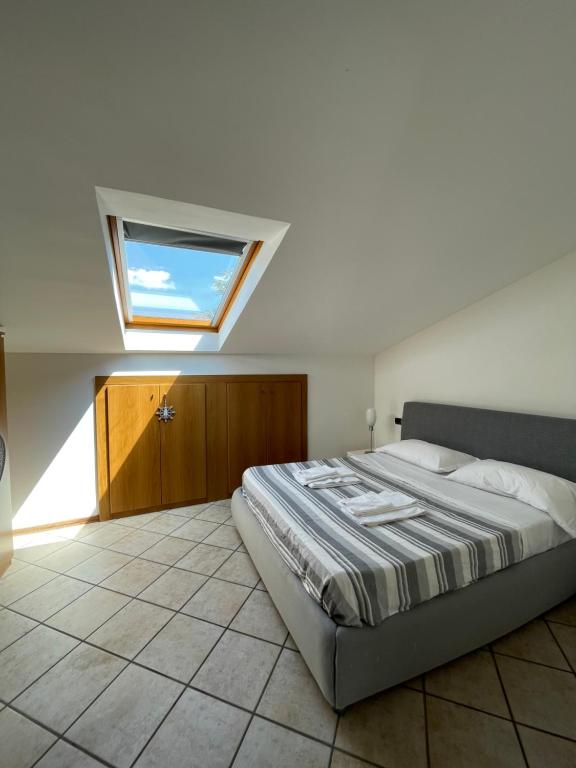 een slaapkamer met een groot bed en een dakraam bij Nico's apartment in Sirmione