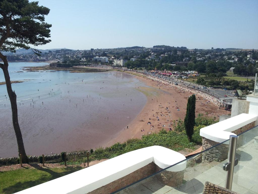Una vista de una playa con gente en el agua. en Riviera Apartment, en Torquay