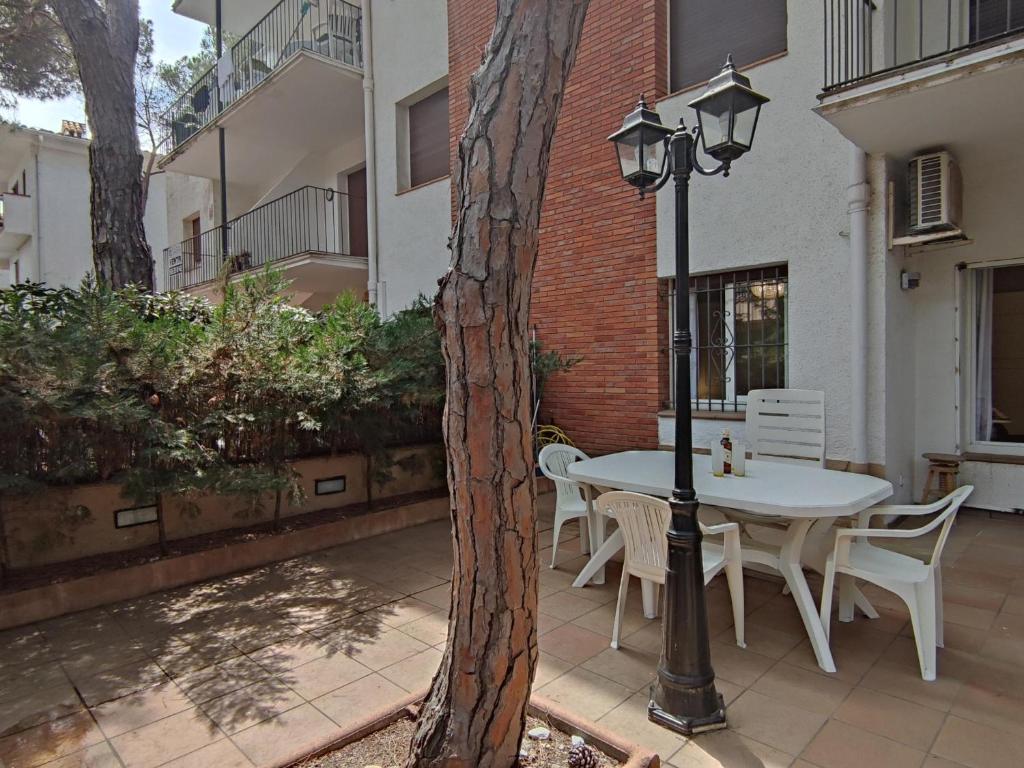 普拉加德阿罗Apartamento con terraza a metros de la playa y zona comercial, ideal familiar - Costa Brava - ES-209-68的天井上配有桌椅和街灯。