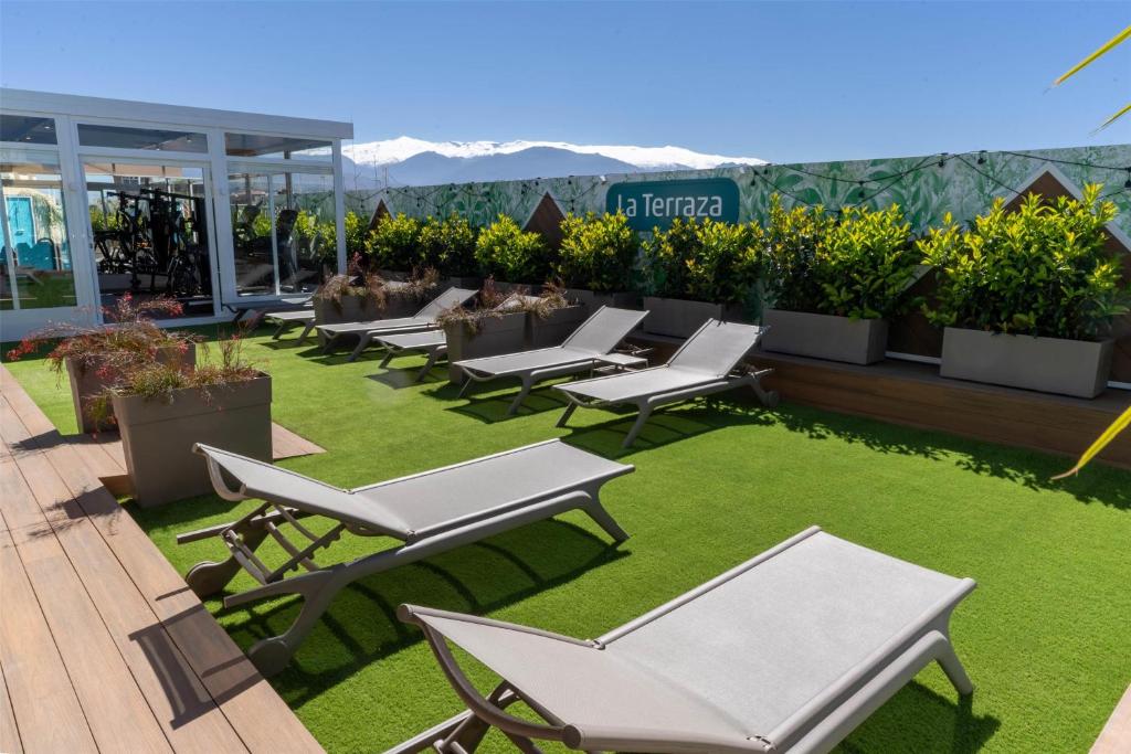 a row of tables and chairs on a lawn at Occidental Granada in Granada
