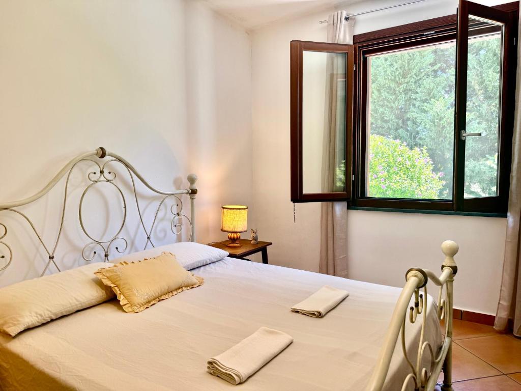 a bedroom with a large white bed with a window at La Segreta in Marina di Casalvelino
