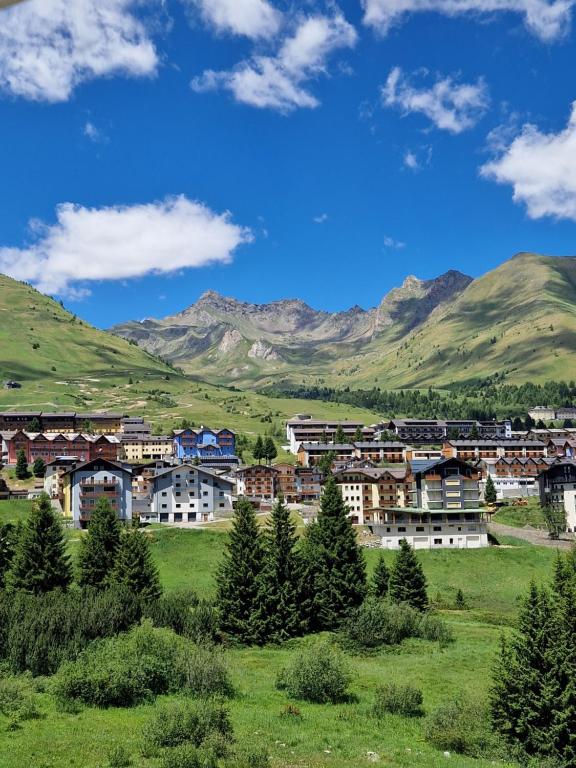 a town in a field with mountains in the background at Casa Dolce Presena in Passo del Tonale