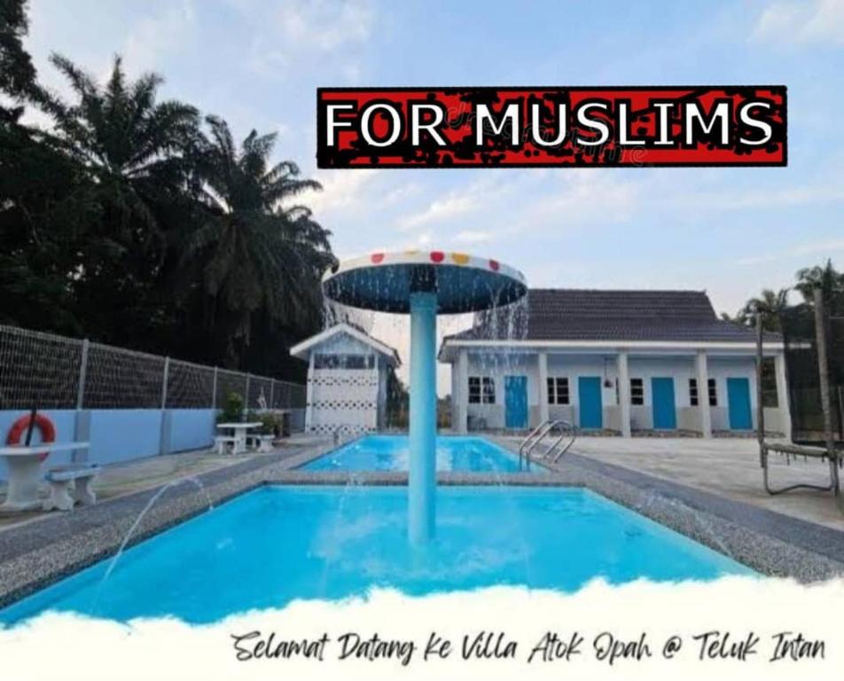 a swimming pool with a sign that reads for muslins at Villa Atok Opah in Teluk Intan