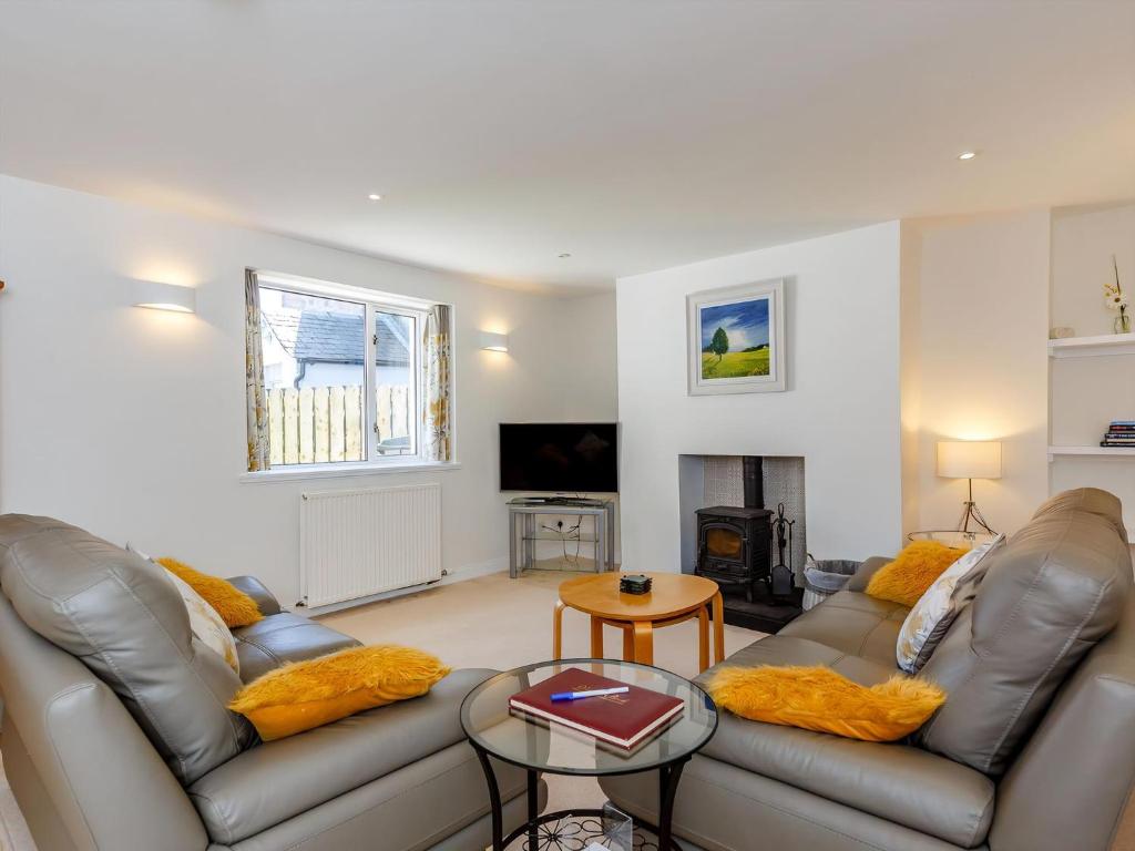 ein Wohnzimmer mit 2 Ledersofas und einem Kamin in der Unterkunft Willow Cottage - Uk39244 in Inverness