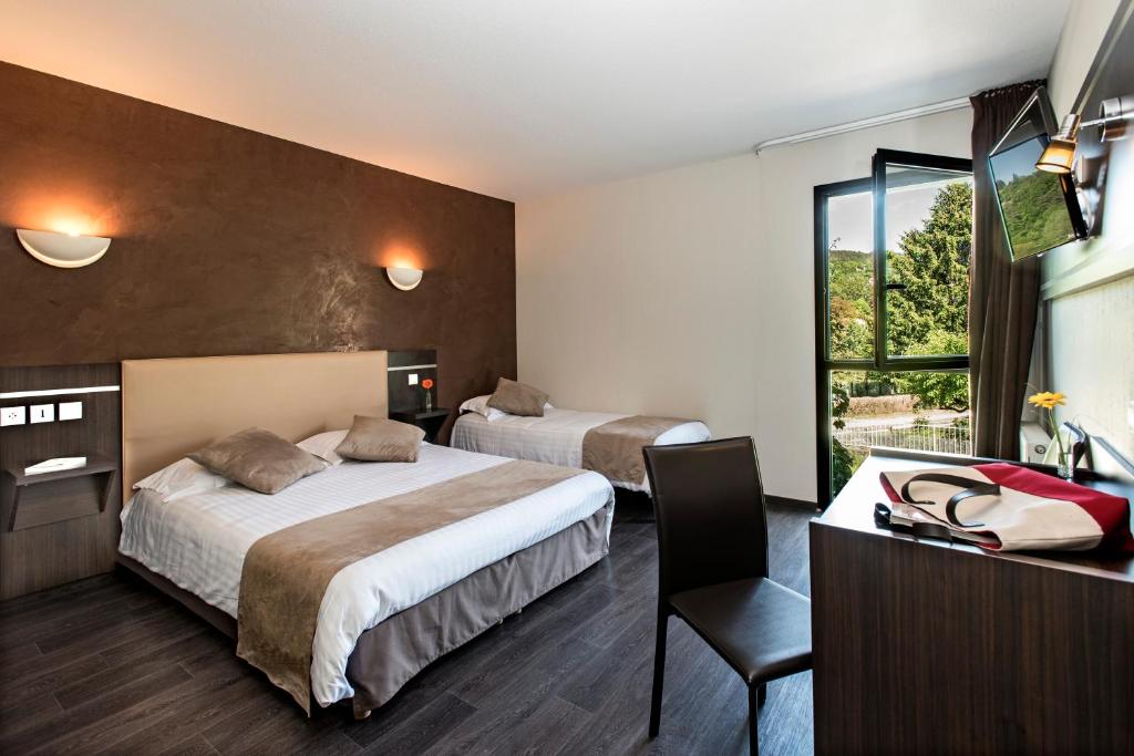 Postel nebo postele na pokoji v ubytování Hôtel-Restaurant Le Calice Du Gevaudan - A75