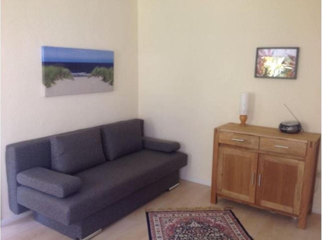 ein Wohnzimmer mit einem Sofa und einem Holzschrank in der Unterkunft Ferienwohnung Kati in Zinnowitz