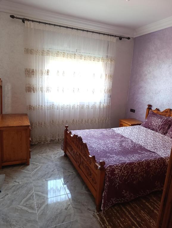 a bedroom with a large bed and a window at فيلا بمولاي بوسلهام in Kenitra
