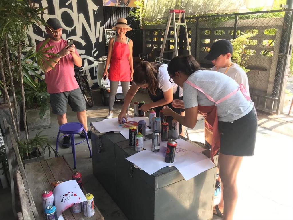 a group of people standing around a table at Addict House A Homely Space in the Old Town with an Art Studio in Ban Yang Pa Kha