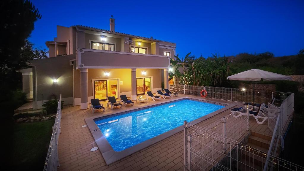 a villa with a swimming pool in front of a house at Atanasio by Check-in Portugal in Albufeira