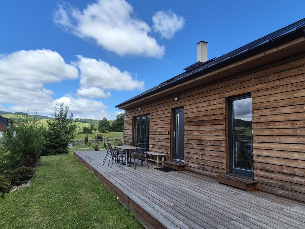 une terrasse en bois avec une table et des chaises sur une maison dans l'établissement Apartmány Stachy Popelná, à Stachy