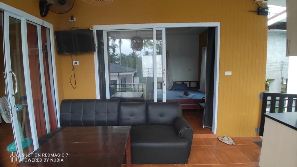 a living room with a couch and a view of a bedroom at Green moonVillage in Ban Nok