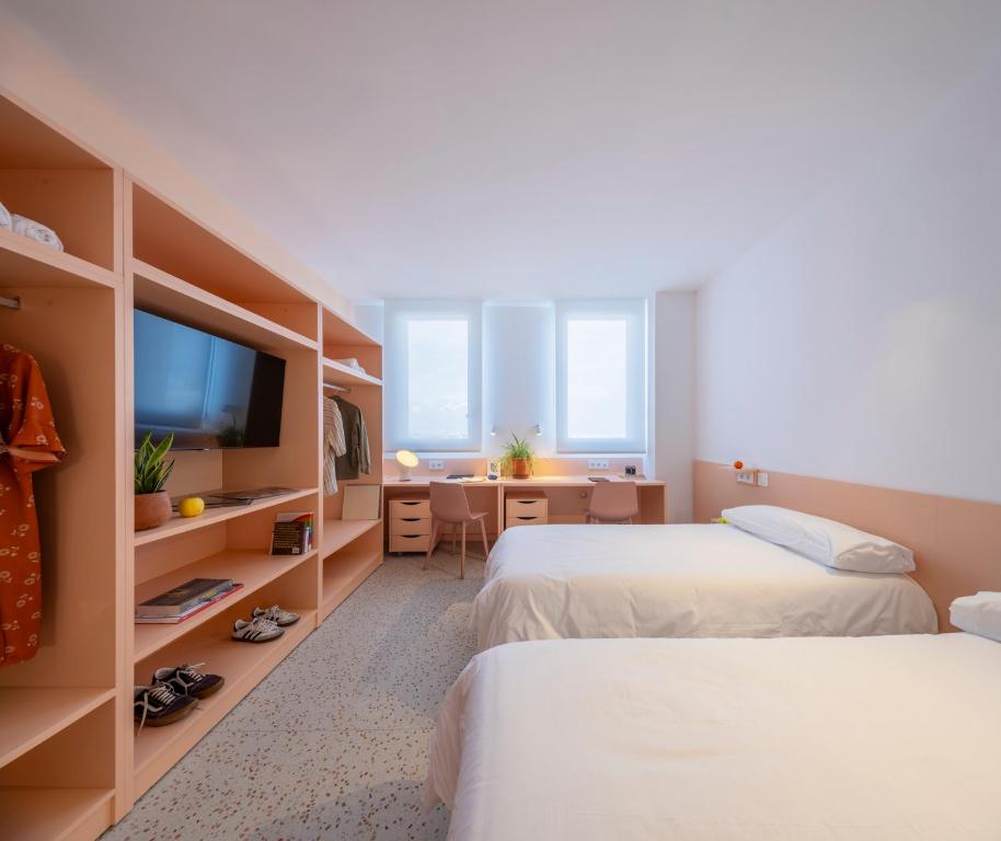 a hotel room with two beds and a television at Hotel Valencia Tower in Burjassot