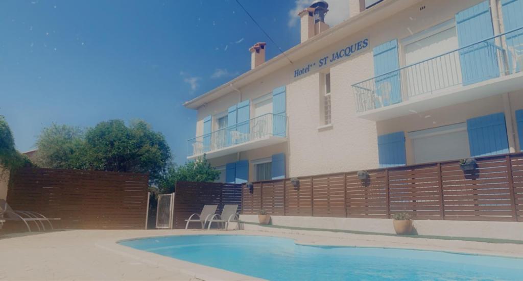 un hôtel avec une piscine devant un immeuble dans l'établissement Saint Jacques, à Sorède