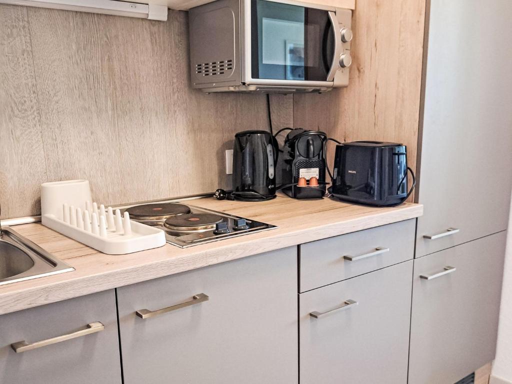 a kitchen with a counter top with a microwave at Apartment Wohnung 306 Berglick by Interhome in Strobl