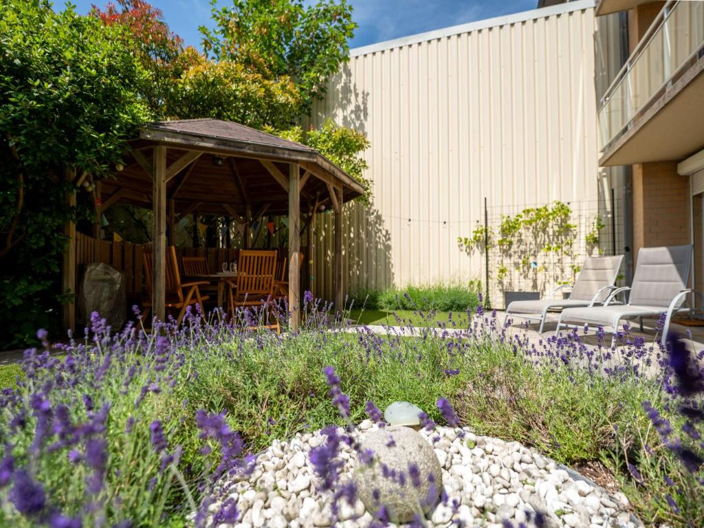 a garden with purple flowers and a gazebo at Apartment Leonifi by Interhome in Bredene