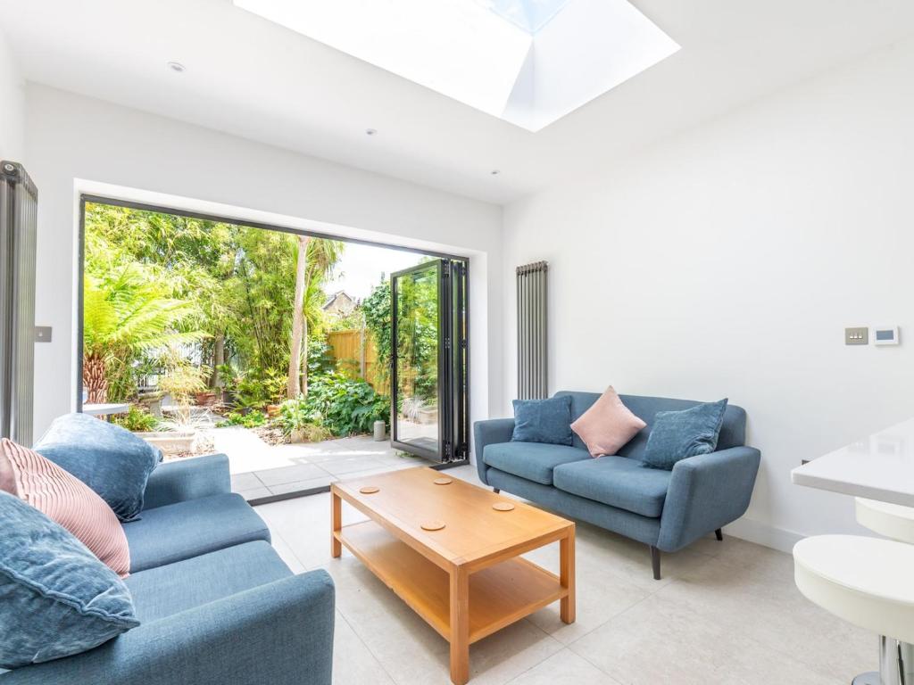 a living room with two blue couches and a table at Pass the Keys Stunning 4Bed Oasis in Kingston With Parking in Kingston upon Thames