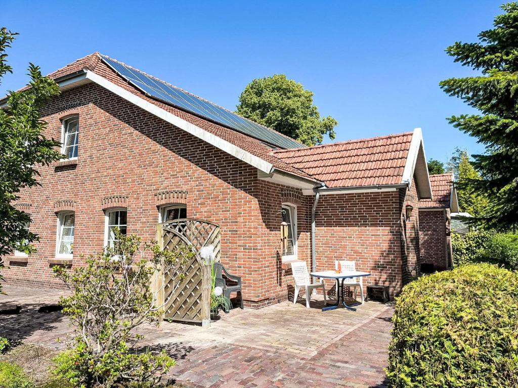 a brick house with a patio and a table at Apartment Krüger-1 by Interhome in Großheide