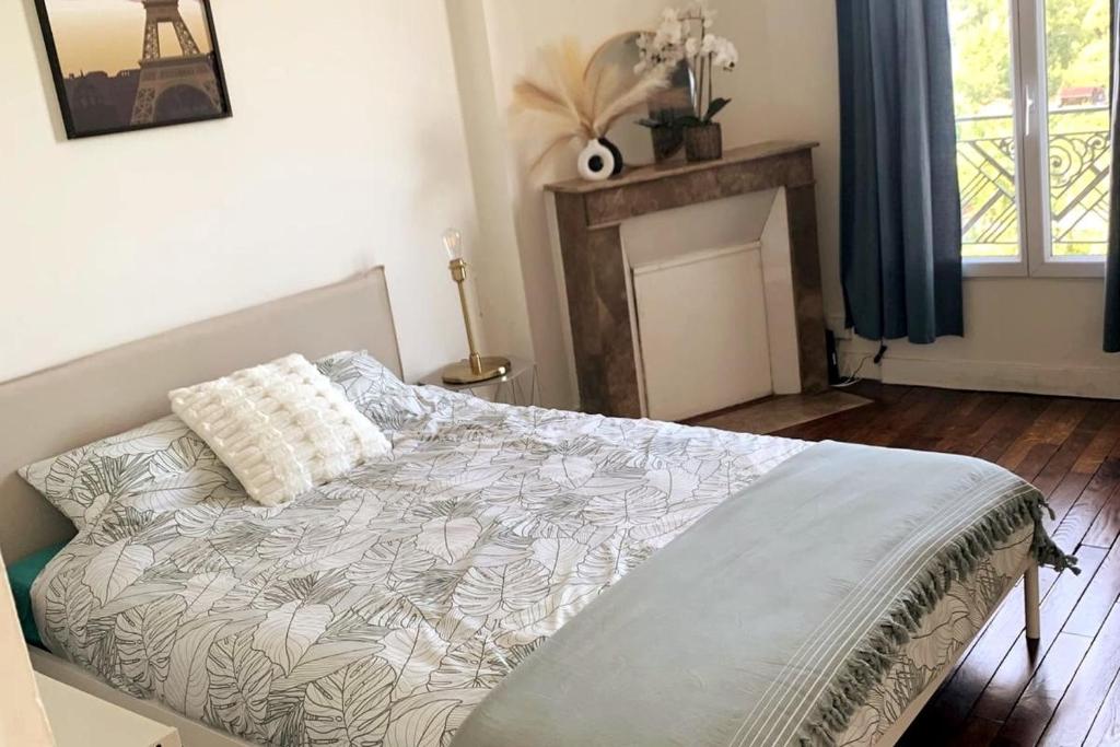 ein Schlafzimmer mit einem Bett und einem Kamin in der Unterkunft F1 Gennevilliers Séjour Pro et Détente in Gennevilliers