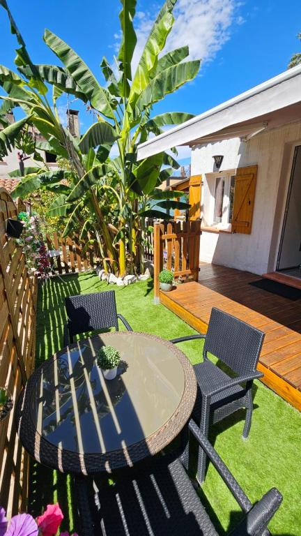un patio avec deux chaises et une table dans une cour dans l'établissement La petite Luciole entre mer et montagne., à Cagnes-sur-Mer