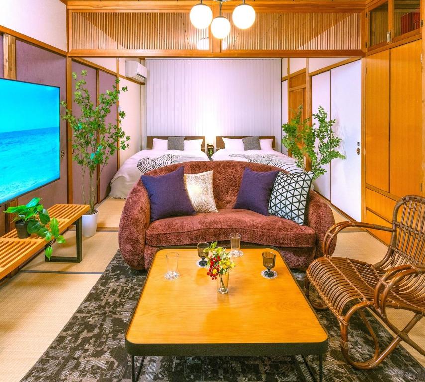 Una sala de estar con un sofá y un televisor. en Kawaramachi Grande Joy, en Takamatsu