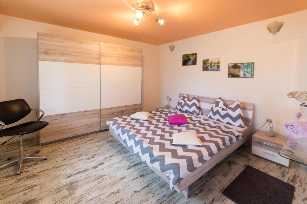 - une chambre avec un grand lit et une chaise dans l'établissement Apartment Stipe, à Solin