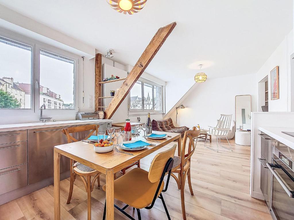 une cuisine et une salle à manger avec une table et des chaises en bois dans l'établissement Apartment Charme et Confort by Interhome, à Vannes
