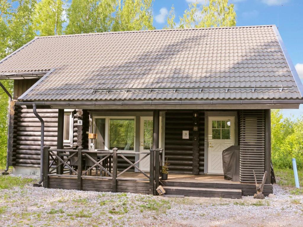 Cette cabane en rondins dispose d'une véranda et d'une porte blanche. dans l'établissement Holiday Home Siili by Interhome, à Savonranta