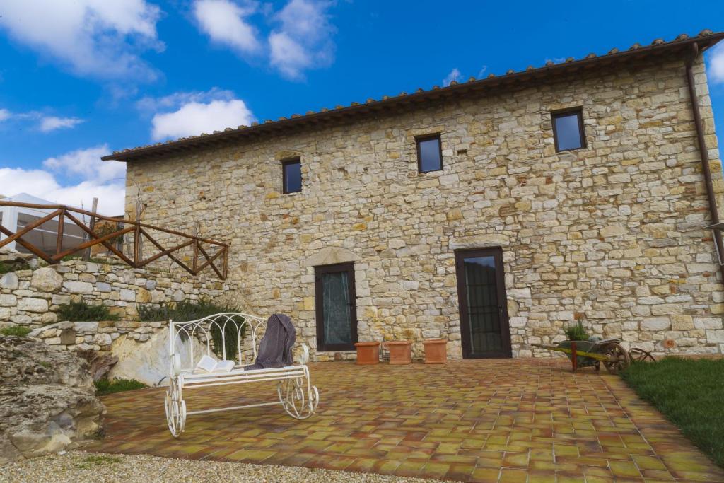una casa de piedra con un banco delante en Borgo di Vezzano en Calenzano