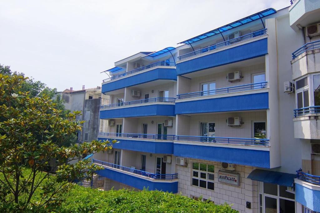 an apartment building with blue balconies on it at Blue Palace Guest House in Budva