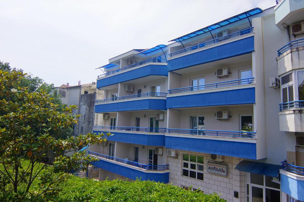 un edificio de apartamentos con balcones azules en Blue Palace Guest House, en Budva