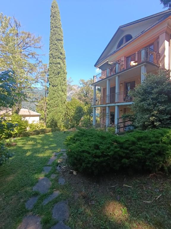a large house with a garden and a tree at Portico sul lago in Oliveto Lario