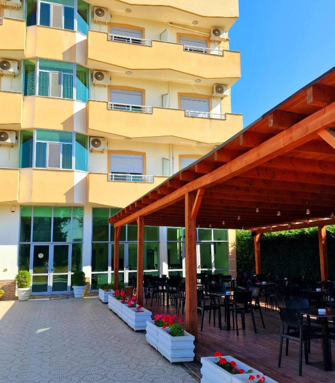 a hotel with tables and chairs and a building at Gurguri Hotel in Golem