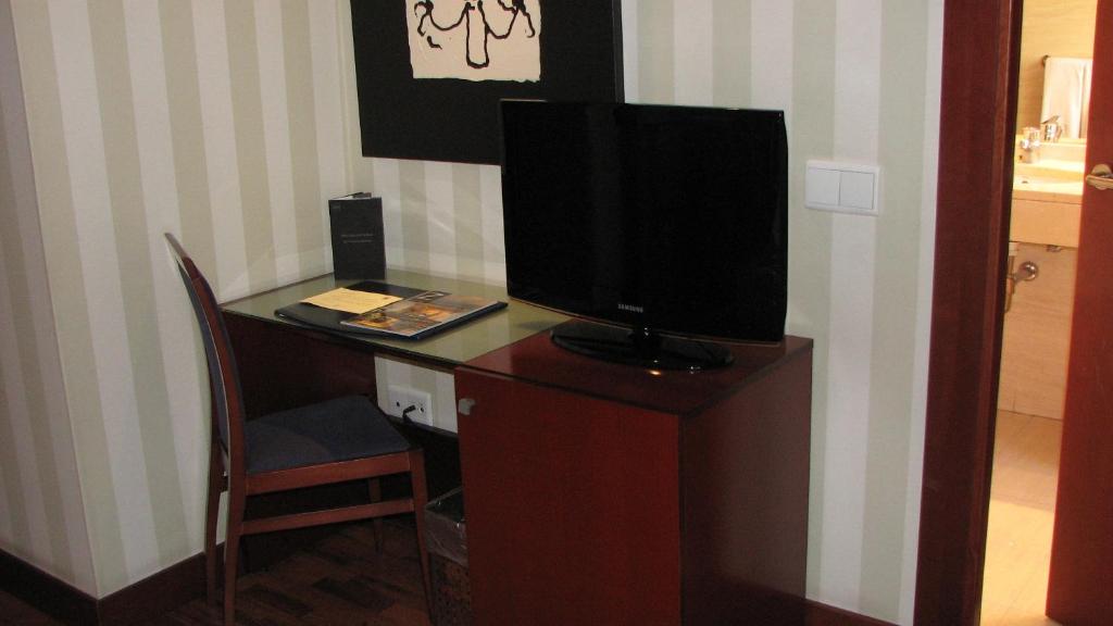 a room with a desk with a television on top at Zenit Málaga in Málaga