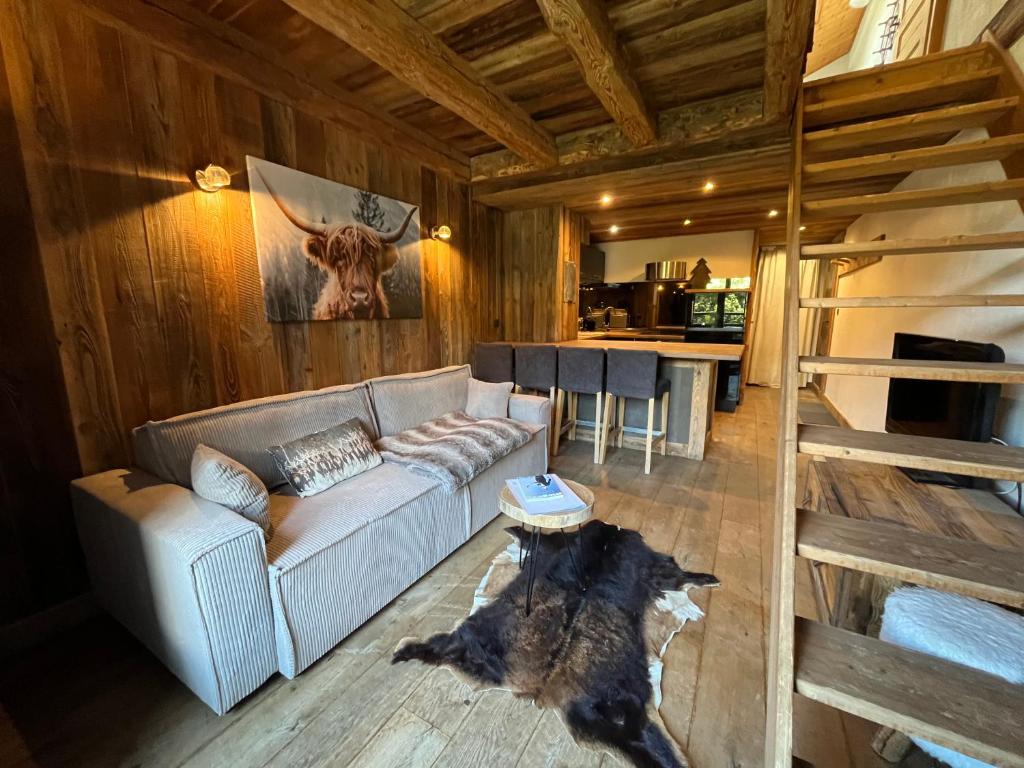 a living room with a couch and a dog laying on the floor at Appartement du Petit Bois in Megève