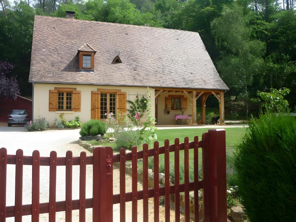 a small house with a fence in front of it at Sous le Tilleul, Chez Joelle et Guy in Carsac-Aillac