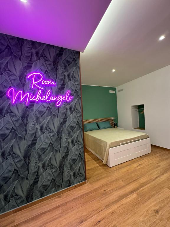 a bedroom with a bed and a purple sign at The Goodtime Michelangelo in Molfetta