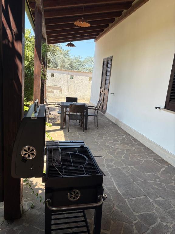 a patio with a grill and a table with chairs at La Locanda della Cupa in San Pietro in Lama
