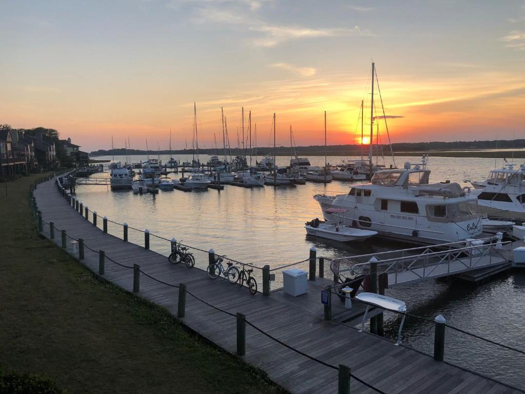 a group of boats docked at a marina at sunset at 1935 Bohicket Marina in Seabrook Island