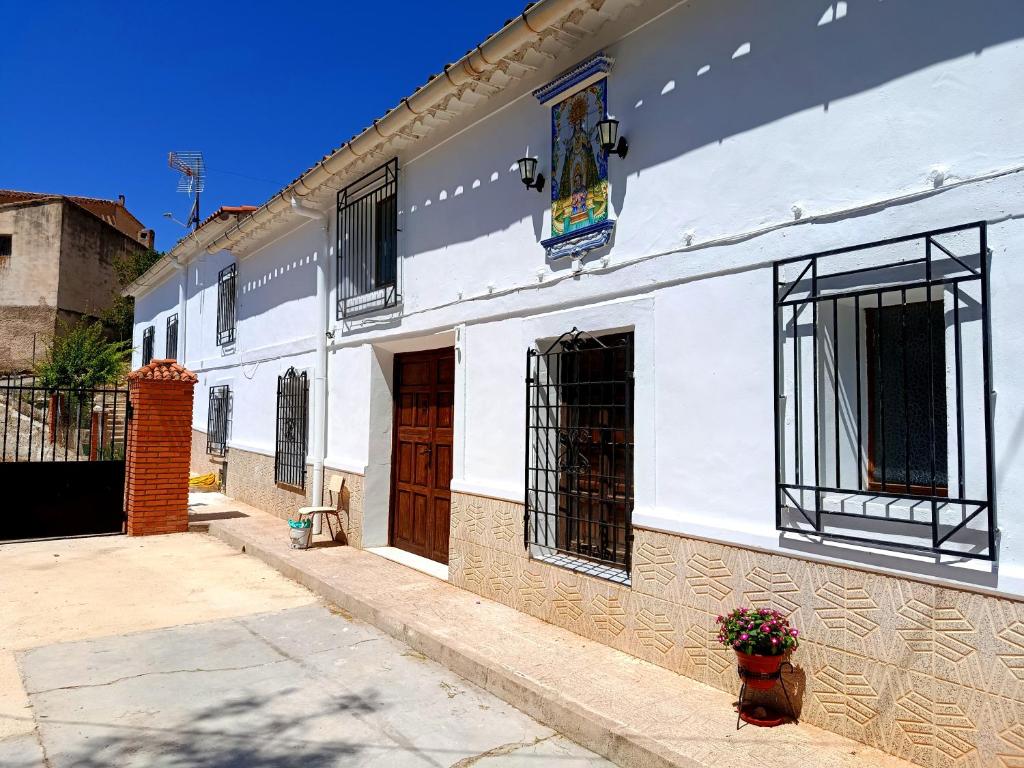 a white building with brown doors and a courtyard at Casas Rurales Mirador del Taibilla in Yeste