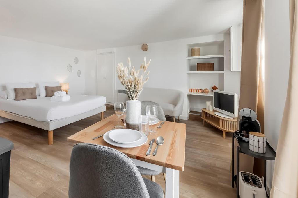 a living room with a dining table and a couch at Bord de l'eau 2 - Studio - Sea view in Cancale