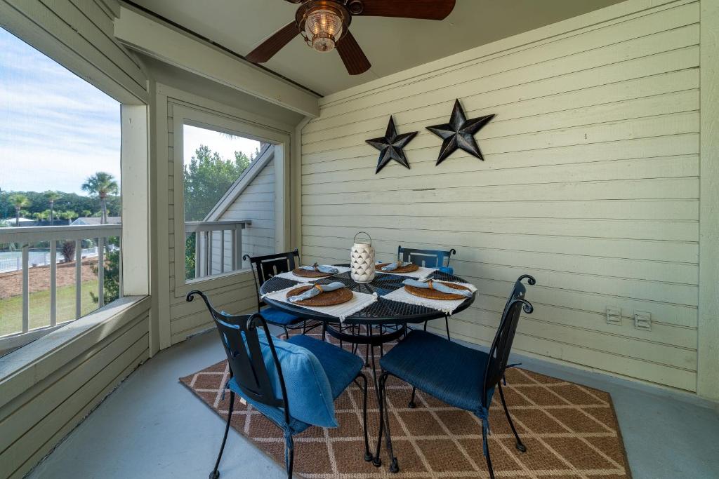 a porch with a table and chairs and stars on the wall at 1644 Courtside Villa in Seabrook Island