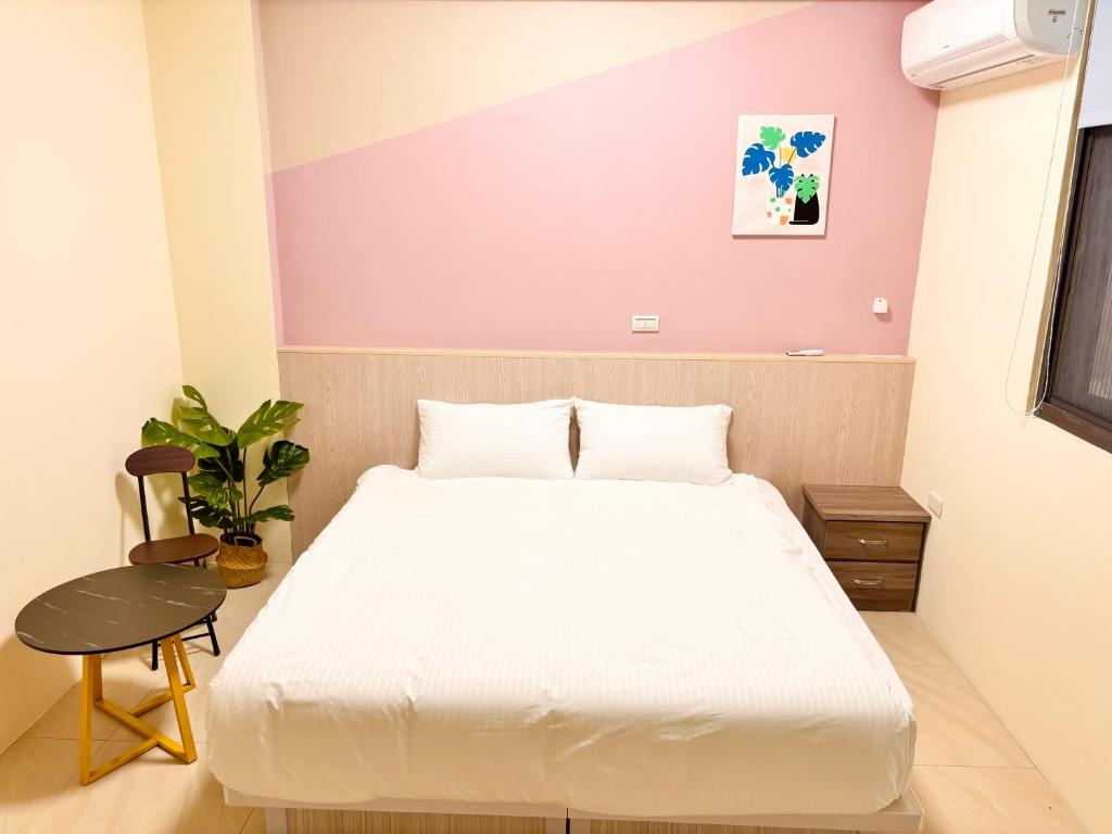a bedroom with a white bed and a purple wall at 玉里步道民宿 in Yuli