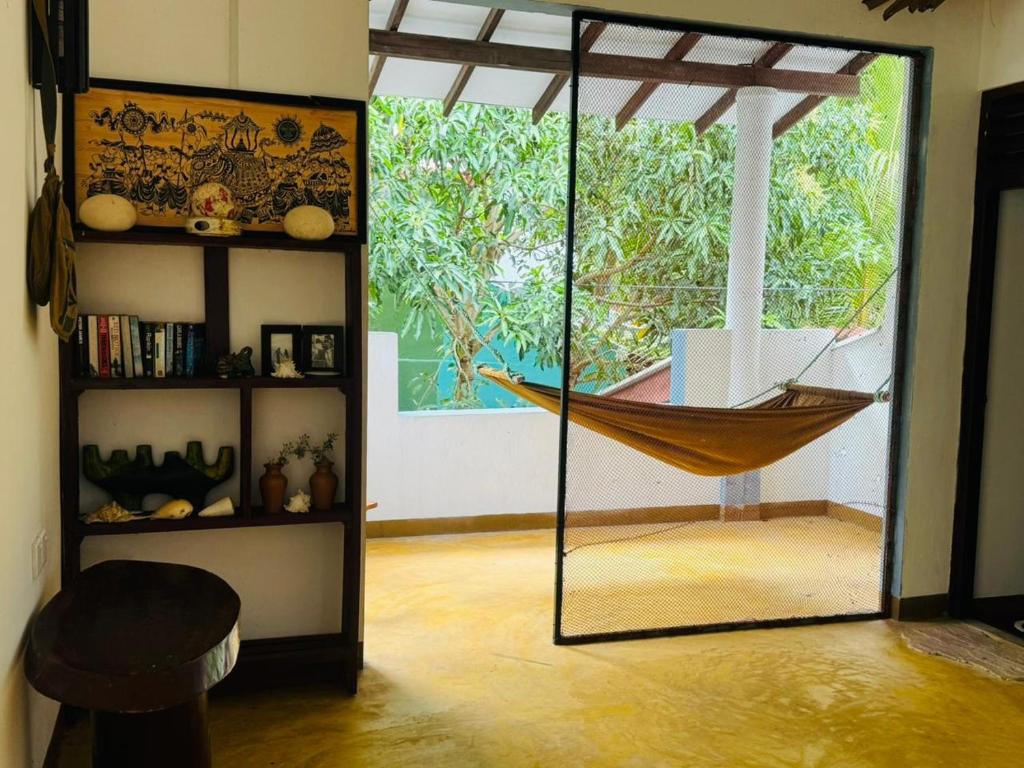 a hammock is hanging in a room with a window at The Village Tangalle in Tangalle